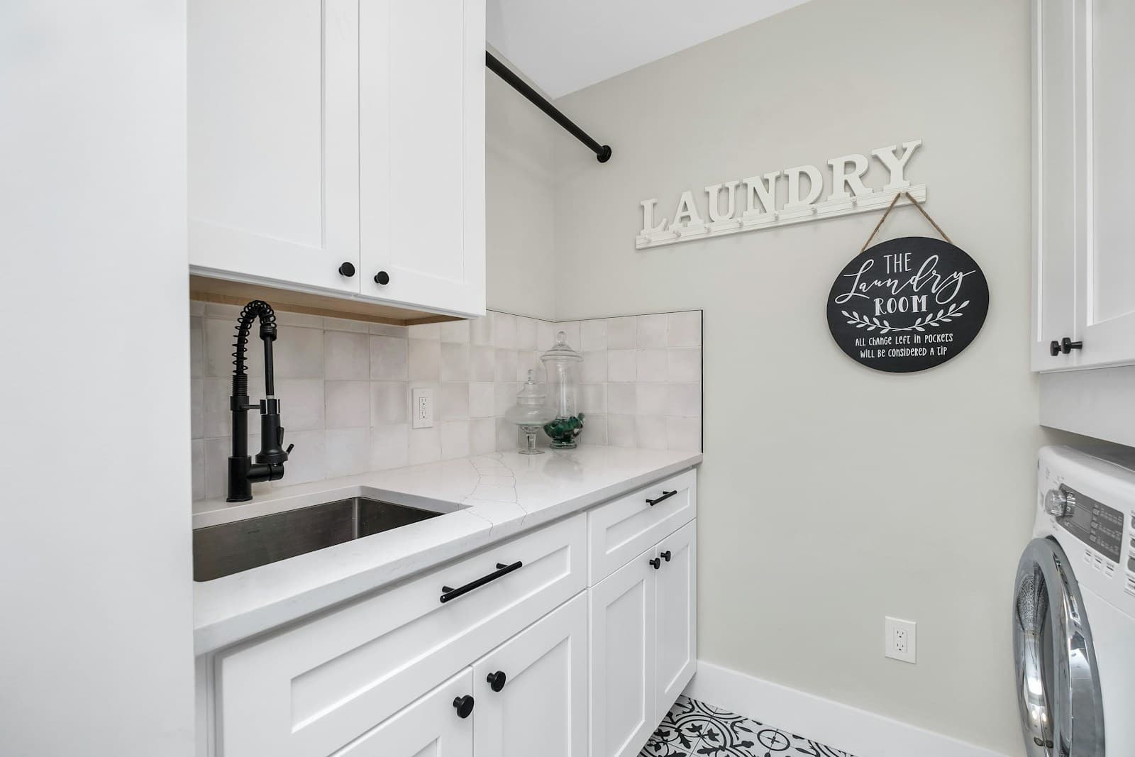 Laundry sink surrounded by white cabinets